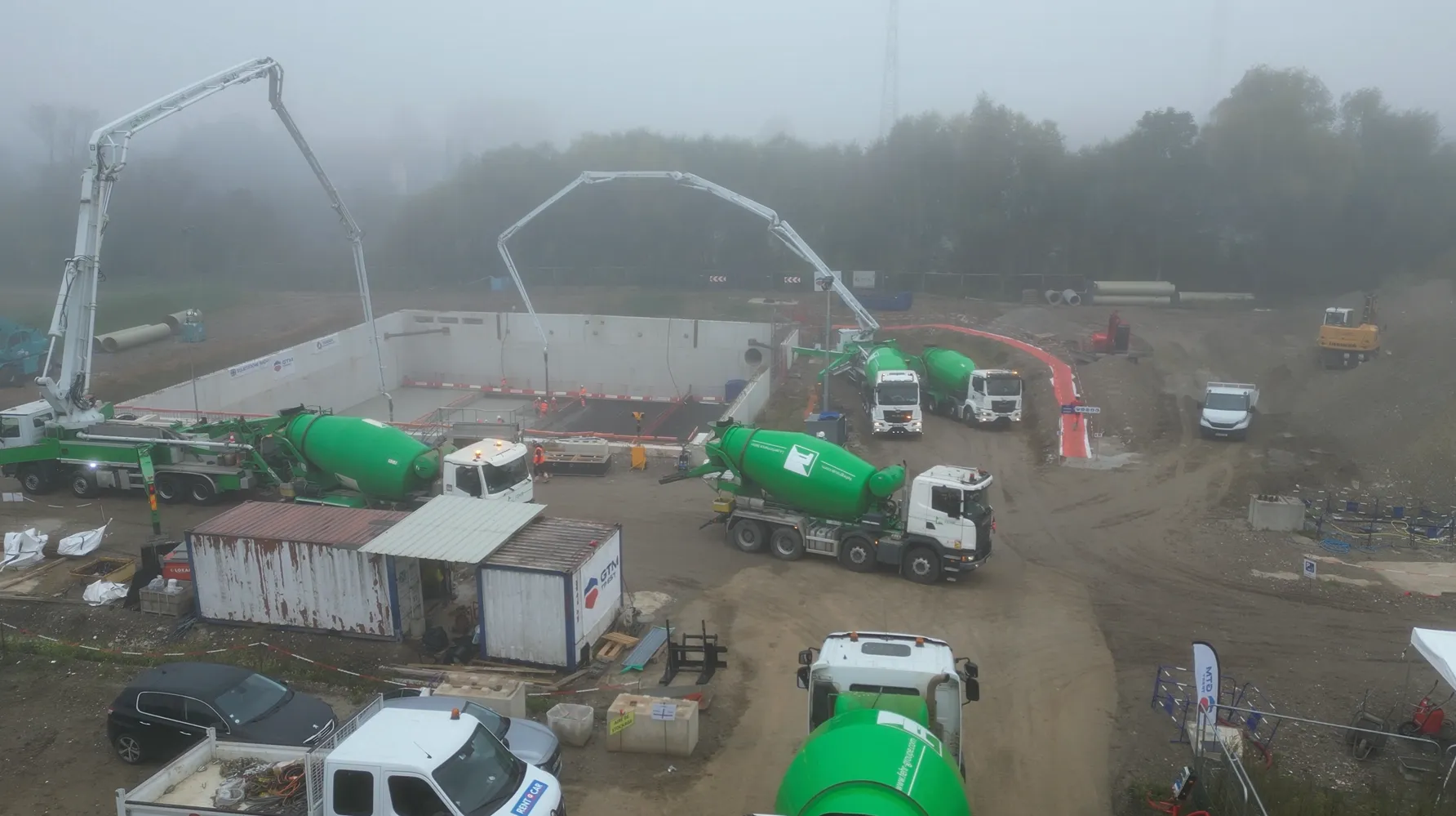 Vue aérienne du chantier bassin d'orage à Mundolsheim, avec 5 camions malaxeurs Fehr qui se relayent pour alimenter les deux pompes à béton longue distance.