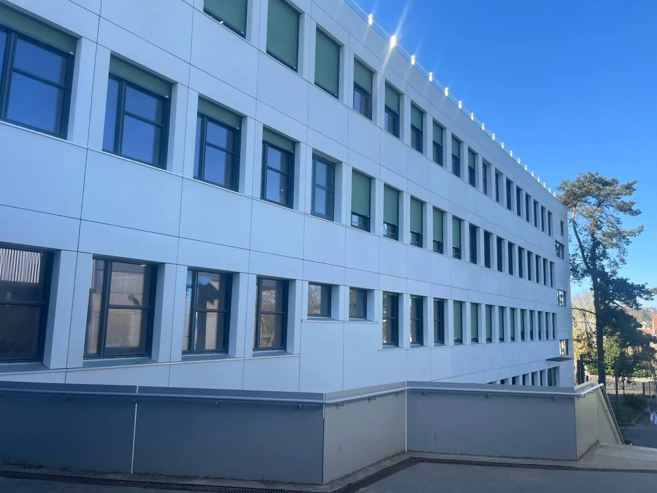 Façade du collège Alexander Fleming à Orsay réalisée avec des panneaux fibrés FClad® Fehr. Garde corps également réalisé en BFHUP.